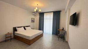 a bedroom with a bed and a flat screen tv at Humor Hotel in Tashkent