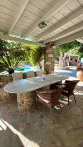 a stone table and chairs on a patio at Paros Casa Prive in Vrachonisída Loúmpinas