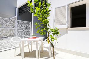 a white table and chairs on a patio with a plant at Umberto I by Casa di Marco in Sannicola