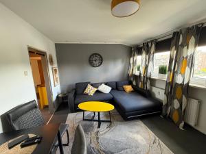 a living room with a couch and a table at Apartment Schmachtendorf in Oberhausen +4 photos