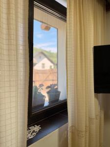 a window with a view of a house at Domeniul Ursului in Valea Stejarului