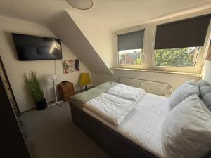 a bedroom with a bed and a flat screen tv at Apartment Schmachtendorf in Oberhausen
