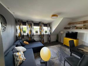 a living room with a blue couch and a television at Apartment Schmachtendorf in Oberhausen