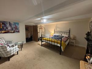 a bedroom with a bed and a couch and a chair at Oaklea House in Stoke on Trent