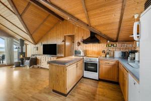 a large kitchen with wooden walls and wooden floors at FJ1602-Jaegerspris-Strandmarksvej-37 in Jægerspris +27 photos