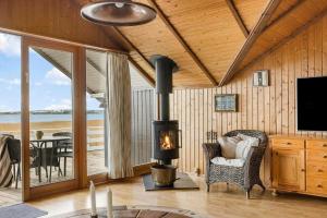 a living room with a fireplace and a table at FJ1602-Jaegerspris-Strandmarksvej-37 in Jægerspris