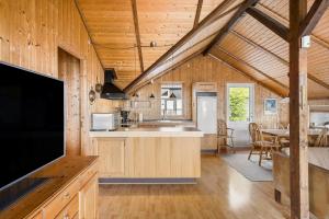 a kitchen and dining room of a log cabin at FJ1602-Jaegerspris-Strandmarksvej-37 in Jægerspris