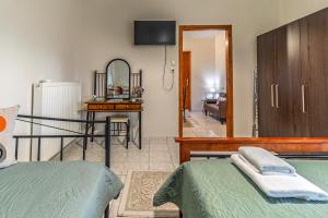a bedroom with a bed and a room with a television at 4 seasons home Ofrinio in Ofrínion