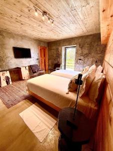 a bedroom with two beds and a tv on the wall at Pocinhobay in Madalena