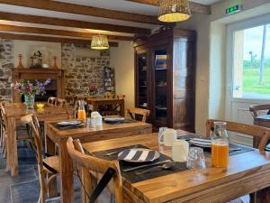 a dining room with wooden tables and chairs at Chez Les Hollandais in Roscanvel +10 photos