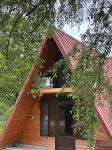 a house with a red roof with a balcony at Helios racha in Ambrolauri