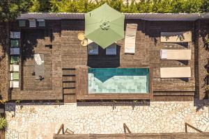 a building with a swimming pool and a green umbrella at Villa Arta by Hostiva in Comporta