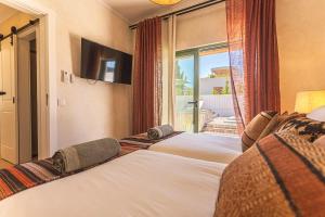 a group of three beds in a room with a window at Villa Arta by Hostiva in Comporta +42 photos