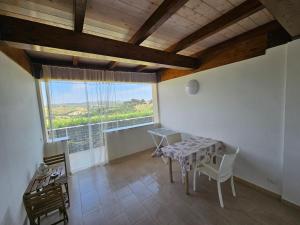 a room with a table and chairs and a large window at Country House Andromeda in Offida