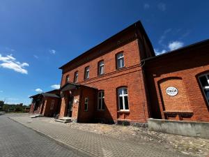 a large red brick building on a street at Noclegi Korzybie in Korzybie