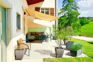 a patio with a table and chairs and an umbrella at La Boutique in Saignelégier +6 photos