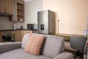 a kitchen with a couch and a refrigerator at Sycamon Suites in Jwaneng
