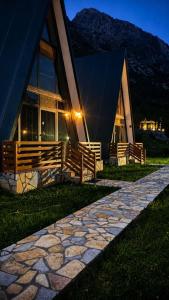 a building with a stone path in front of it at Arditi's Chalets in Bogë