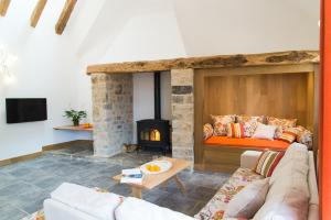 a living room with a couch and a fireplace at L'etable de pierre in Nojaret