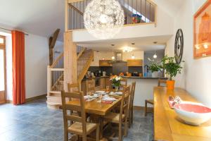 a kitchen and dining room with a wooden table and chairs at L'etable de pierre in Nojaret