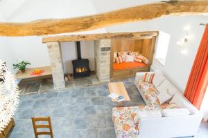 a living room with a couch and a fireplace at L'etable de pierre in Nojaret