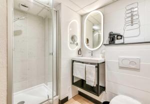a bathroom with a shower and a toilet and a sink at B&B HOTEL Perpignan Centre in Perpignan