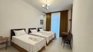a hotel room with two beds and a table at Humor Hotel in Tashkent