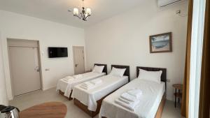 a room with two beds and a tv in it at Humor Hotel in Tashkent +3 photos
