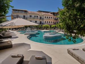 a large swimming pool with chairs and an umbrella at Hotel President Solin in Solin +51 photos
