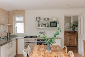 a kitchen with a wooden table with a vase on it at The Roost in Westport