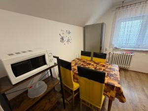 a dining room with a table and yellow chairs at Penzion Hedvika in Kravaře