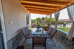 a patio with a table and chairs on a balcony at 4 seasons home Ofrinio in Ofrínion