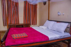 a bedroom with a large bed with a red blanket at Jumbo Art S Villas in Diani Beach +39 photos