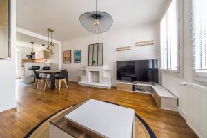 a living room with a television and a table at Le Balcon Gaillard in Brive-la-Gaillarde