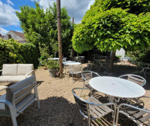 a group of tables and chairs in a yard at Logis Hôtel Le Merle Blanc in Digoin