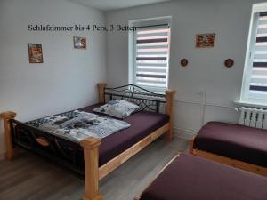 a bedroom with two beds and two windows at FeWo s Runde Wiese WR in Greifswald