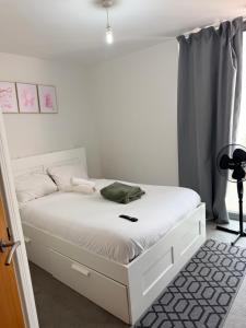 a bedroom with a white bed with a phone on it at Cozy One bedroom with Free Underground parking in Mailbox Birmingham city in Birmingham