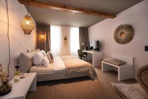 a bedroom with a bed and a desk and a couch at Hotel Fuchs in Saarbrücken