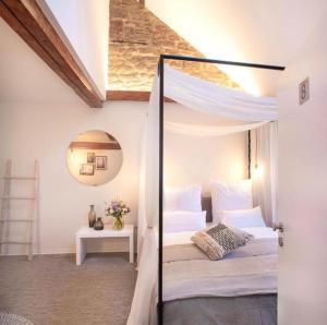 a bedroom with a canopy bed and a mirror at Hotel Fuchs in Saarbrücken