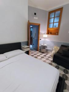 a bedroom with a bed and a couch at Bell'e Buono vicino aeroporto di Capodichino in Naples