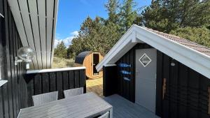a black shed with a white roof on a deck at BV422-Blavand-Hedetoftvej-2 in Blåvand