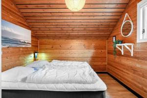 a bedroom with a bed in a wooden wall at BV422-Blavand-Hedetoftvej-2 in Blåvand