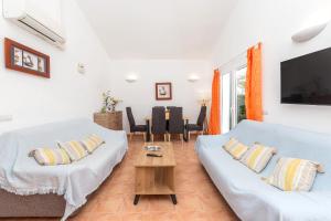 a living room with two white couches and a table at Villa Jaume in Cala en Bosc