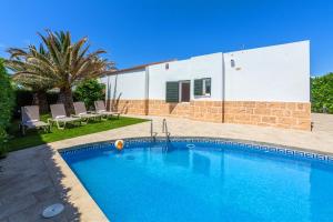 a swimming pool in front of a house at Villa Jaume in Cala en Bosc