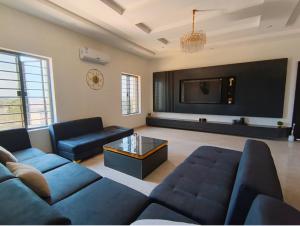 ein Wohnzimmer mit Sofa und Fernseher in der Unterkunft Dpounds Hotel & Suites in Okinano