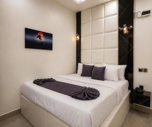 ein Schlafzimmer mit einem weißen Bett und einem Bild an der Wand in der Unterkunft Dpounds Hotel & Suites in Okinano