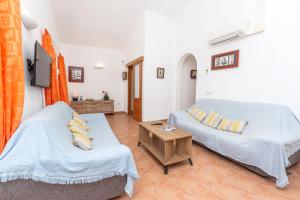 a living room with two beds and a table at Villa Jaume in Cala en Bosc +21 photos