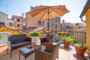 a patio with chairs and an umbrella on a balcony at Hotel Falier in Venice