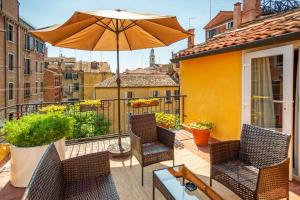 a patio with chairs and an umbrella on a balcony at Hotel Falier in Venice