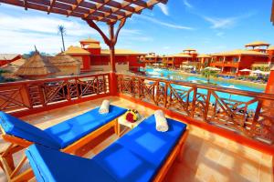 a resort balcony with blue chairs and a swimming pool at Pickalbatros Alf Leila Wa Leila Resort - Neverland Hurghada in Hurghada